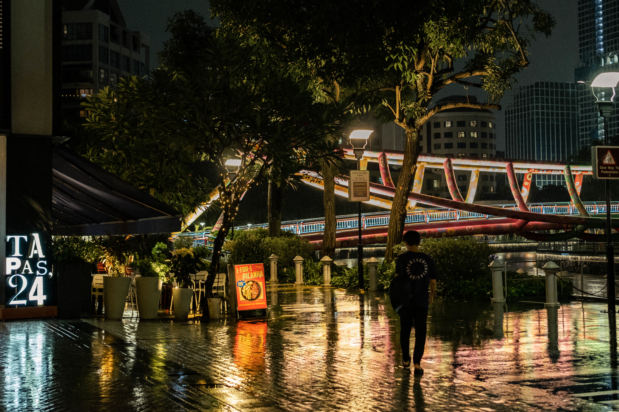 Neon reflections on rain-soaked streets at night near Clarke Quay, Singapore, by Scott Yip
